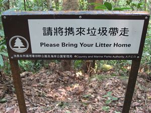 A sign in a Hong Kong park that says "Please Bring Your Litter Home".