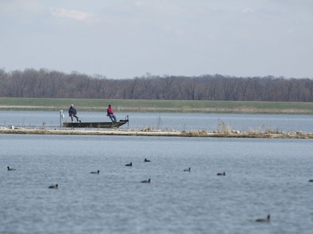 Two adults fishing on a small boat at Emiquon Preserve in Lewiston, Illinois.