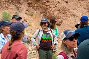 A group of people gathered and talking in a dirt ditch.