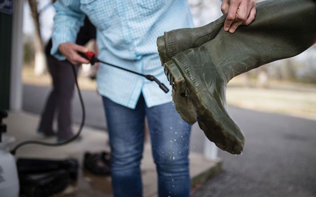 TNC staff cleaning boots with bleach spray after use at Pontotoc Ridge Preserve. 