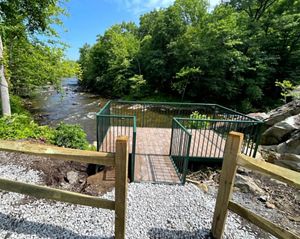An overlook platform facing a river with blue skies above.