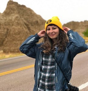 Candid photo of Development Program Associate Melisa Soysal in an open plateau with sandstone formations lining the horizon.
