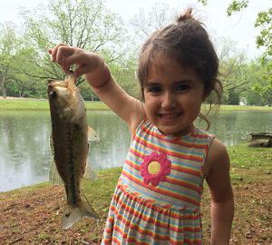 Girl holding a fish at the pond at Rattlesnake Ridge Natural Area.