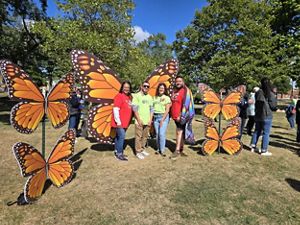 People standing in front of a butterfly display.