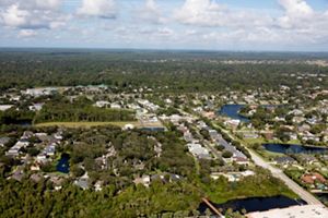 An aerial photo shows a residential area with tree cover.