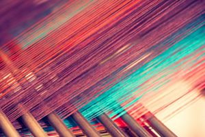 Multicolored straight strands, sewing equipment, loom equipment at a garment factory.