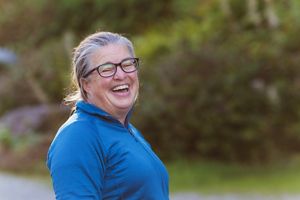a woman in glasses laughing outside
