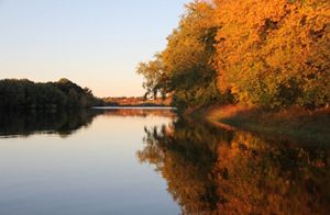 Fall colors reflect off a river.