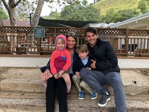 The Sprague family sitting for a photo in front of a park.