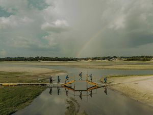 Los trabajadores de un astillero caminan por la orilla seca del río Puracaquequara. Anteriormente podían acceder a su lugar de trabajo en barco, pero debido al descenso del nivel del agua, ahora deben recorrer parte del trayecto a pie para llegar a una sección del río que aún es navegable.