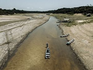 a very low river with dry banks and beached boats.