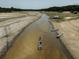 Un hombre arrastra una barca por el centro poco profundo de un río cerca de la comunidad de São Francisco de Marina, que ha quedado aislada debido al bajo nivel del agua en los ríos locales.
