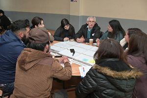 a group of diverse people sits around a table and discusses sphagnum moss harvesting.