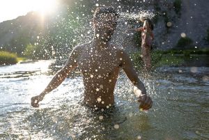 A person splashes water while swimming in the Krupa River.