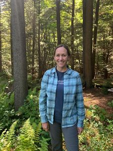 Markelle Smith, landscape partnership manager, stands in a lush green forest.