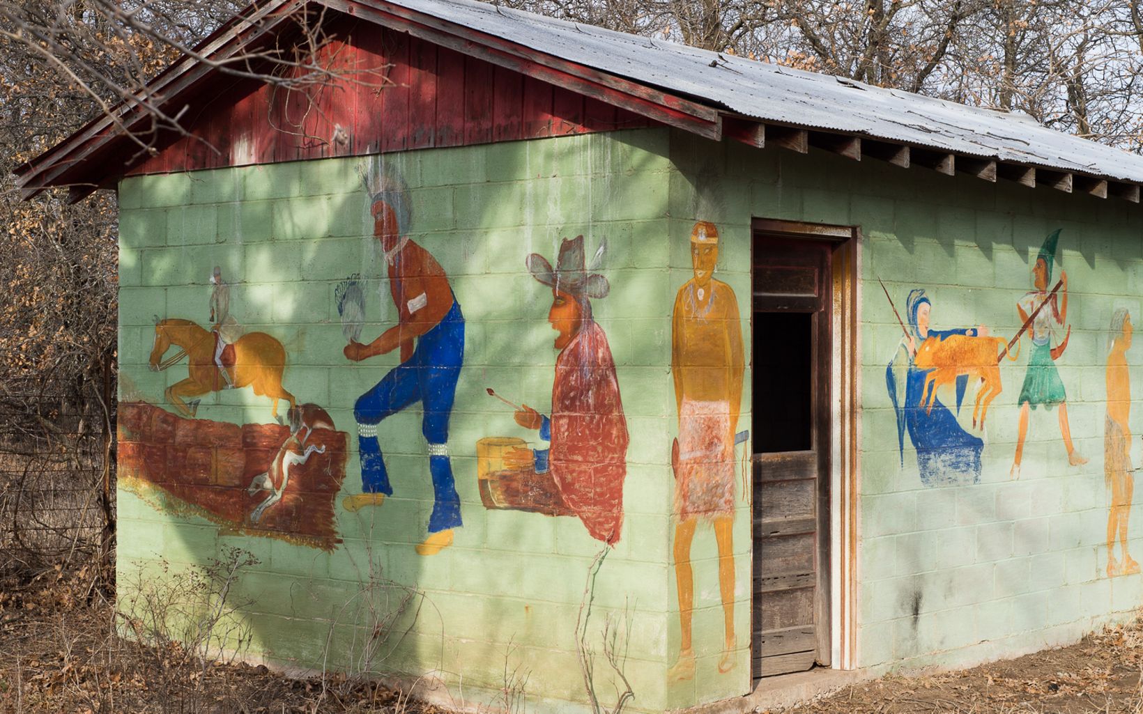 Outbuilding Art Mathews painted his depiction of the history of man on his outbuilding near the cabin. © George Pierson