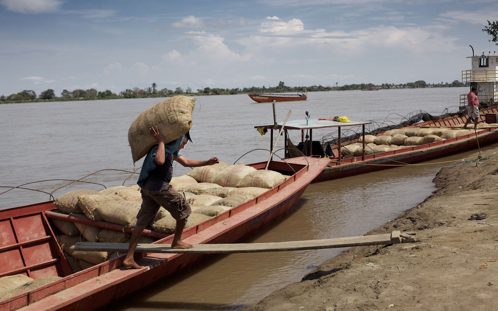 A man unloads goods from his boat on the Magdalena River in Colombia. 