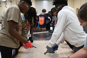 A group of young people work with wire.