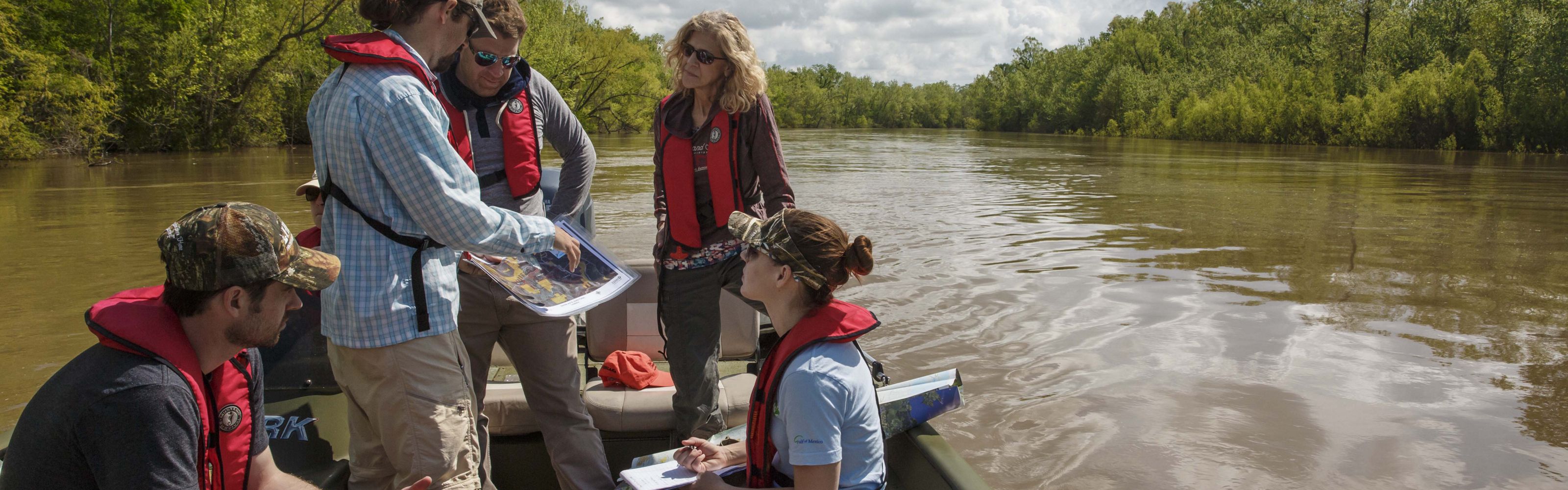 A group of people on a boat in the Atchafalaya River Basin.