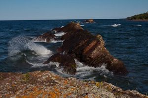 Rocks jutting out of Lake Superior on the Mary Macdonald Preserve shoreline under a blue sky. The preserve is located in the Keweenaw Peninsula in Michigan's Upper Peninsula.