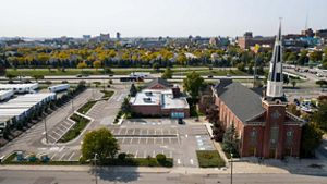Aerial image of the church with the city of Detroit spread out behind it. 