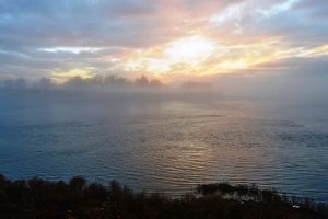 A pink sunrise frames a calm river.