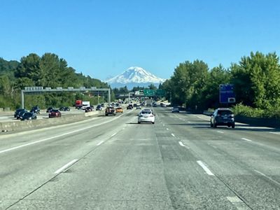 The snowy slopes of Mount Rainier are visible in the distance from Interstate 5 in Seattle.