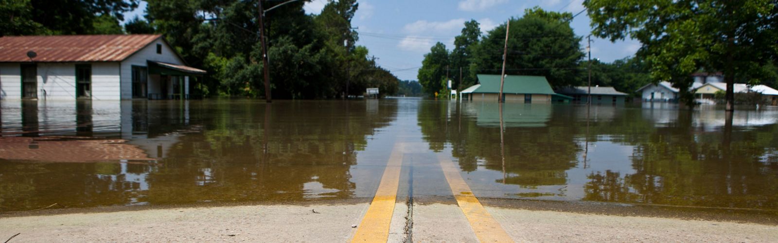 High water from mississippi river flooding a road with double yellow line in louisiana