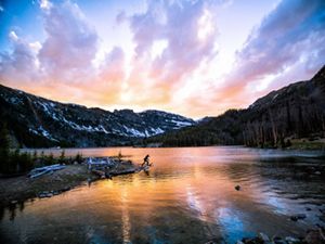 SOUTH MEADOW CREEK LAKE. Colorida puesta de sol durante una cálida noche de verano en South Meadow Creek Lake, en las montañas Tobacco Root, Montana. 
