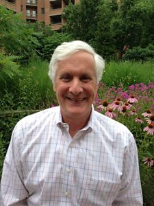 A man standing in front of flowers.