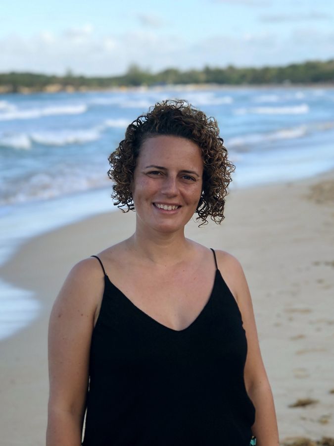 a portrait of a smiling woman on a beach