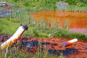 Pipe drips clean water into a wetlands from mine run off.