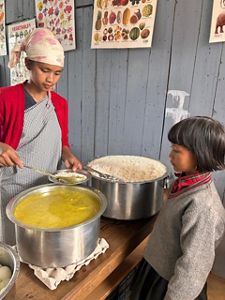 A young girl is getting served a meal. 