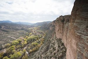 Canyon walls overlook a mountain range.