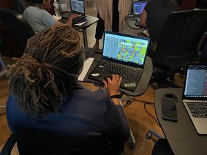A woman uses a computer to map green space. 