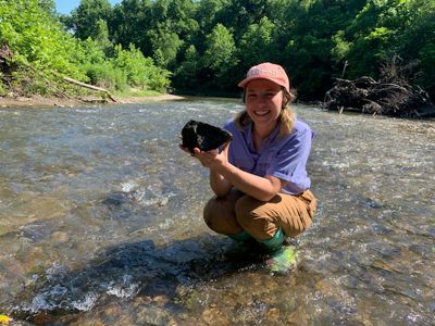 Person in a stream smiling.
