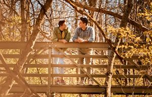 Chad Duplain stands with partner Matthew on bridge overlooking stream at Big Darby Headwaters Nature Preserve.