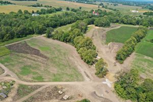 Aerial view of newly dug stream beds winding through patches of forest.