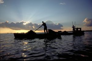 silhouette of a person on a small boat