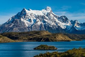 Paisaje con lago y en el fondo montañas cubiertas de nieve en Torres del Paine. 