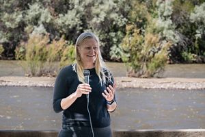 A blonde woman holding a microphone and speaking to a crowd.