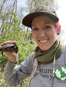 A selfie of Elizabeth Hanson holding a small turtle.