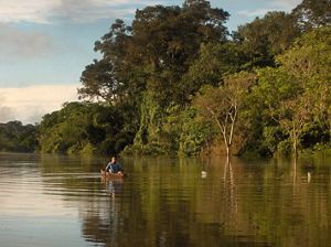 niño navega por el un río en la Amazonía Peruana