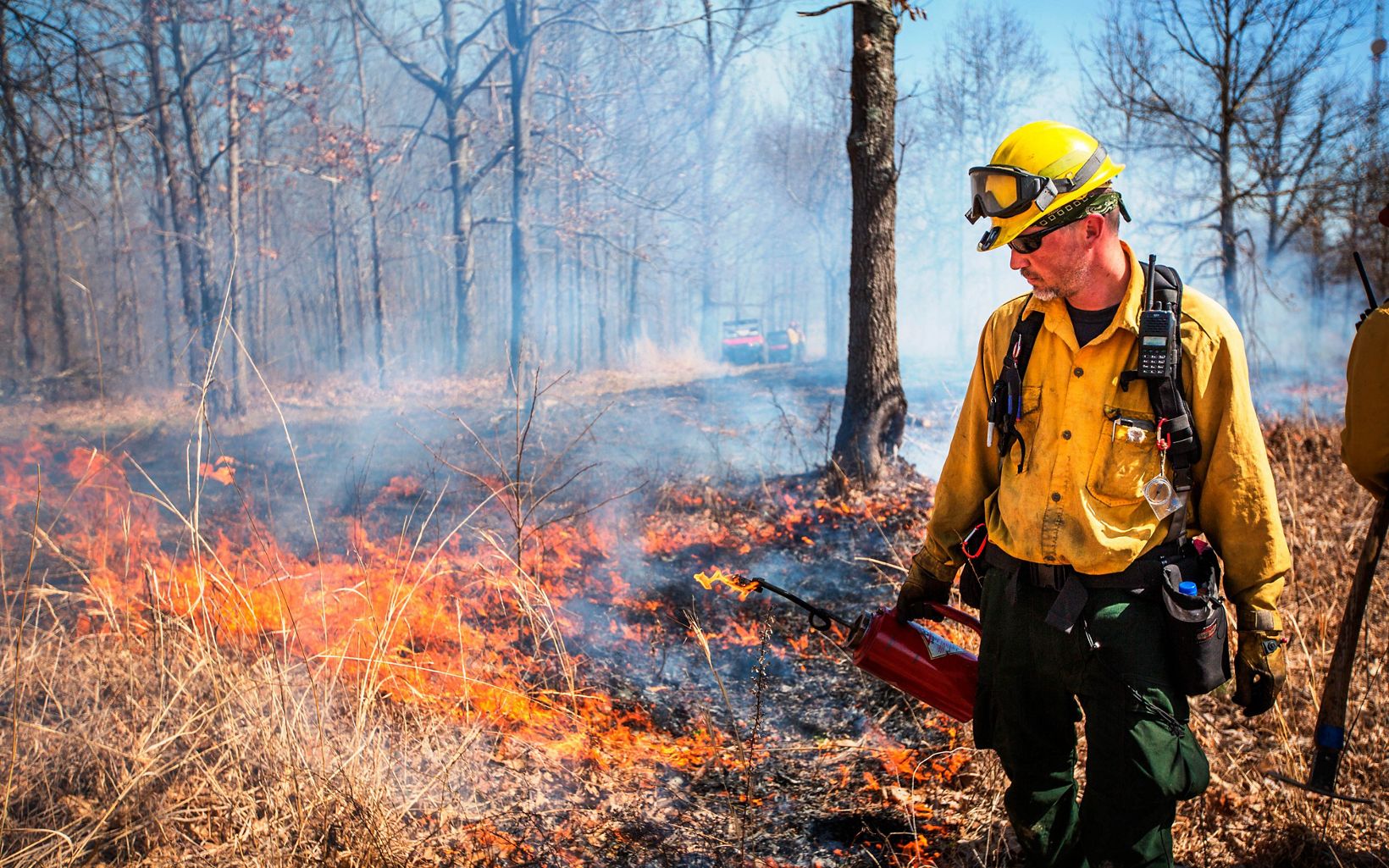 Kentucky Fire Management  Prescribed fire works its way through an open area behind Josh Lillpop of the Office of Kentucky Nature Preserves.  © Mike Wilkinson