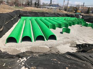 Green underground cistern tubes being layed out in a grid.