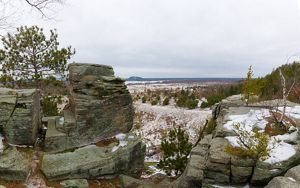 Panoramic view over the wintry landscape from the rocky, snow-covered bluffs dotted with birch and conifer trees at the Quincy Bluff and Wetlands State Natural Area.