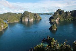 Small rocky islands rise out of calm blue waters.