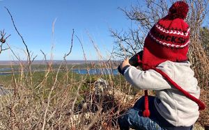 child with binoculars looking out at Rattlesnake Ridge
