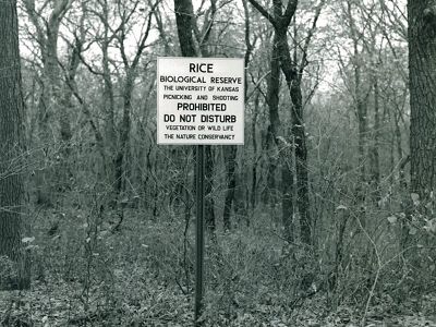 Old photograph of metal preserve sign in front of tress
