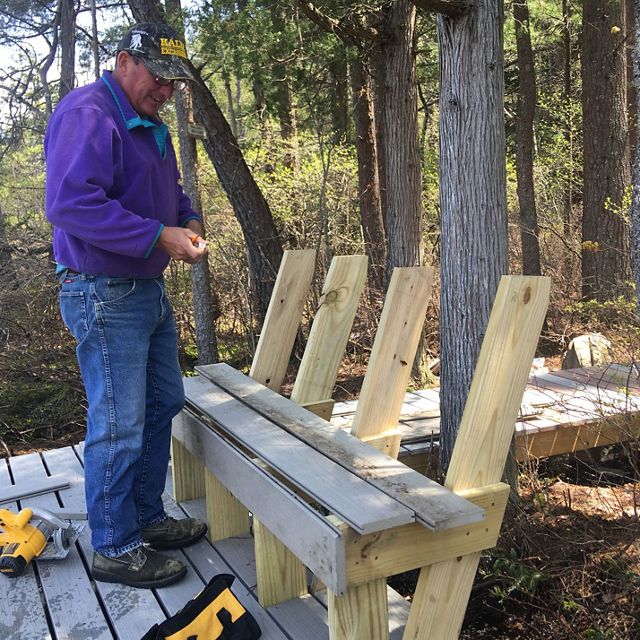 A volunteer helps build a new viewing platform and bench at Saco Heath preserve.